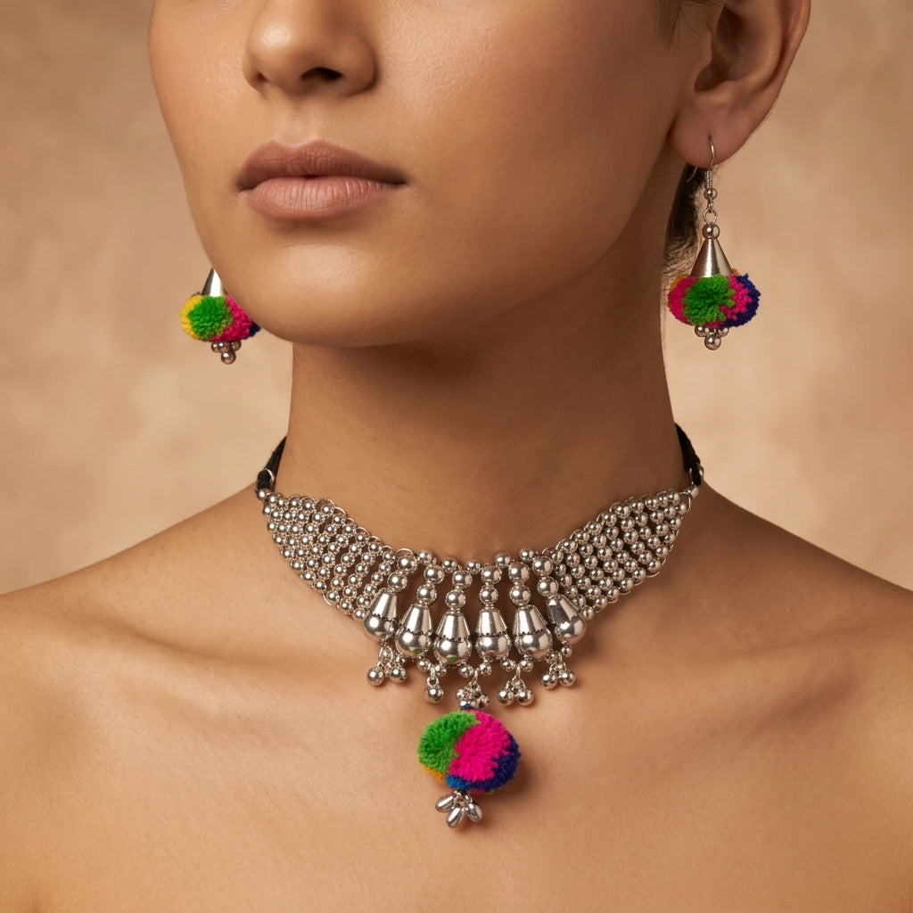 Dangling multicolour pom-pom earrings shown worn beside a matching statement necklace