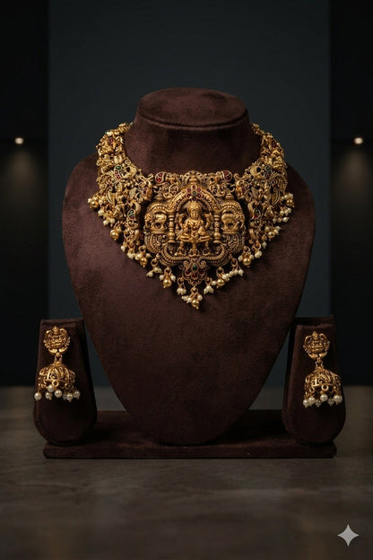 Front view of ornate necklace on brown bust, with matching-looking earrings displayed on either side