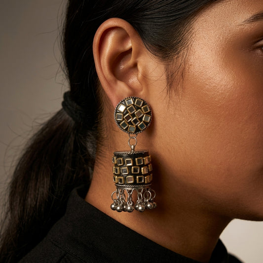 Close-up side view showing a geometric drop earring with dangling bead details