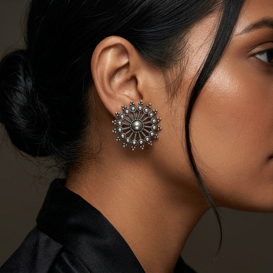 Close-up side view of a round sunburst earring worn against the ear