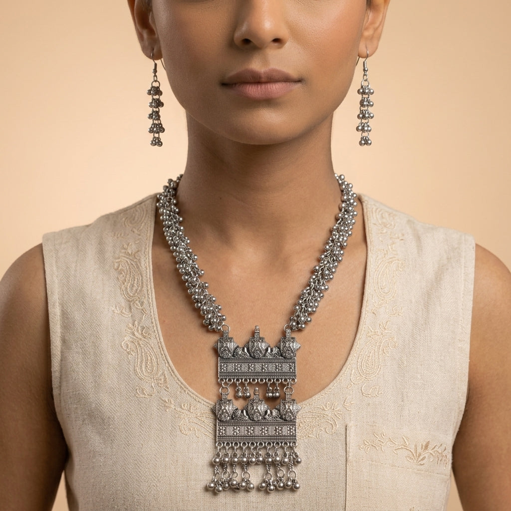 Front view of tiered beaded drop earrings worn beside the face, with necklace visible